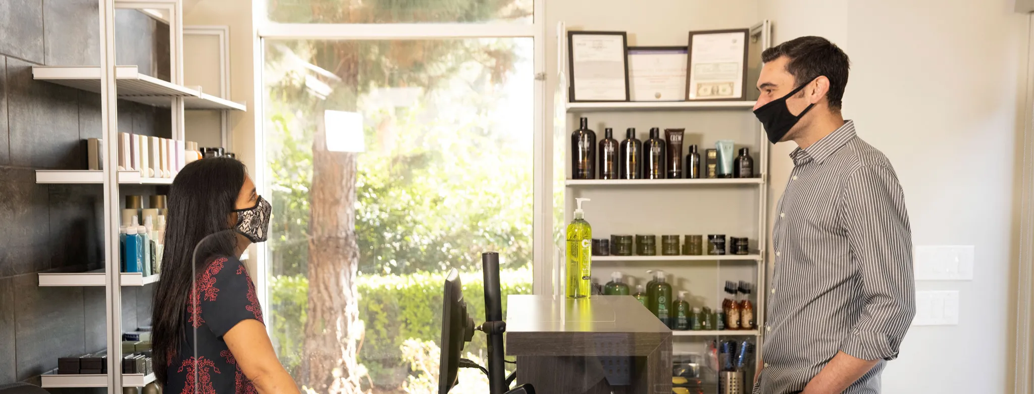 salon stylists helping male client at checkout