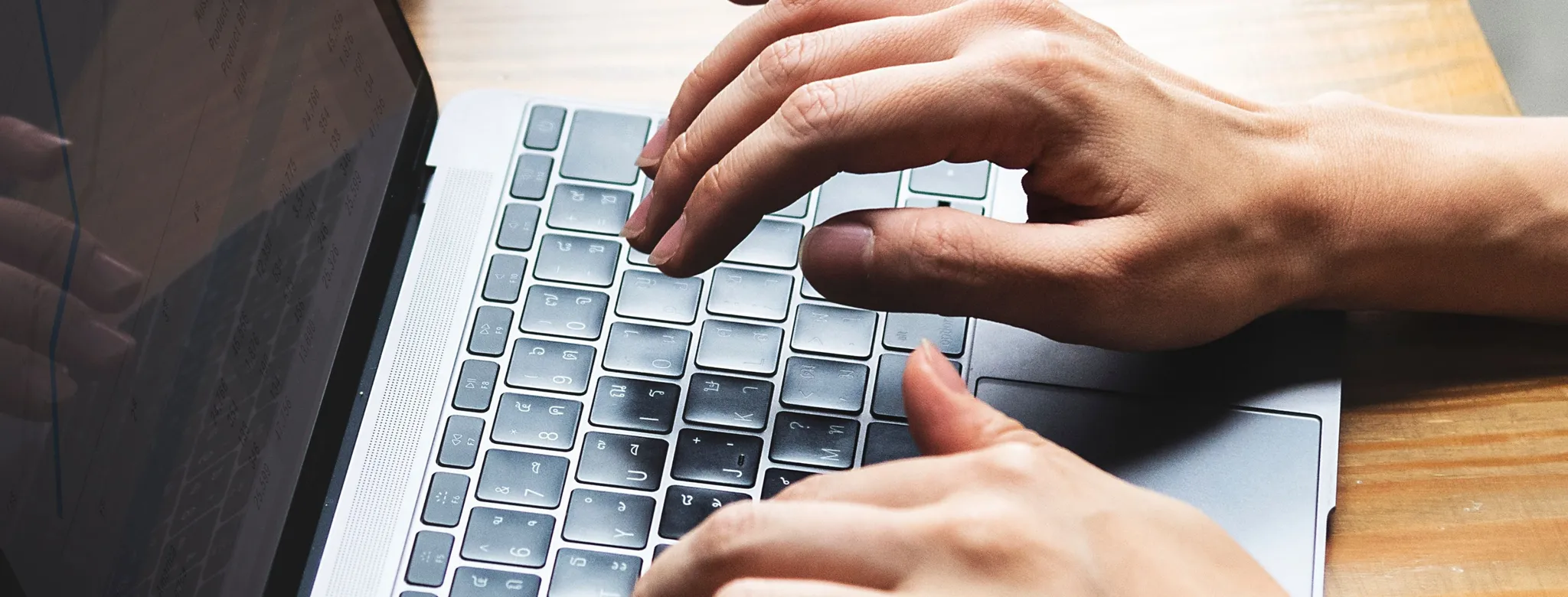 Hands typing on a Macbook