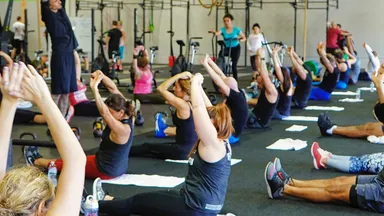 group of people working out and stretching in gym