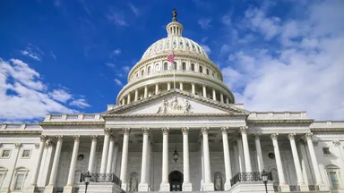 The Capitol Building in Washington, DC in front of a blue sky