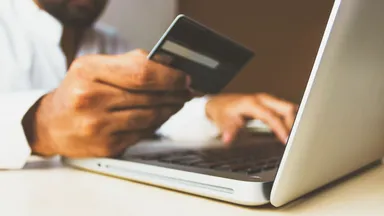 Person inputs credit card information into a laptop