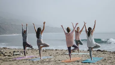 women doing yoga on the beach